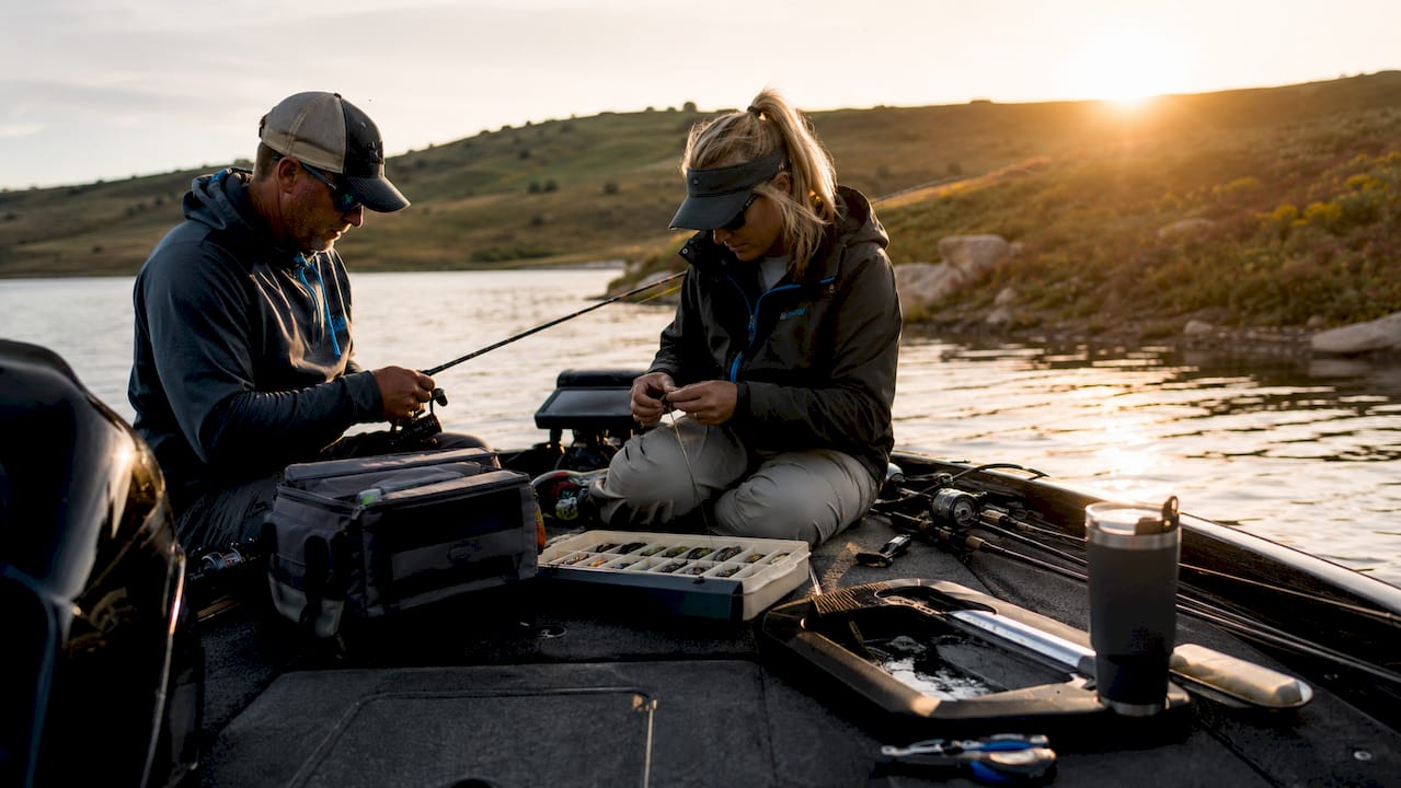 Anglers preparing boat for fishing tournament at sunrise