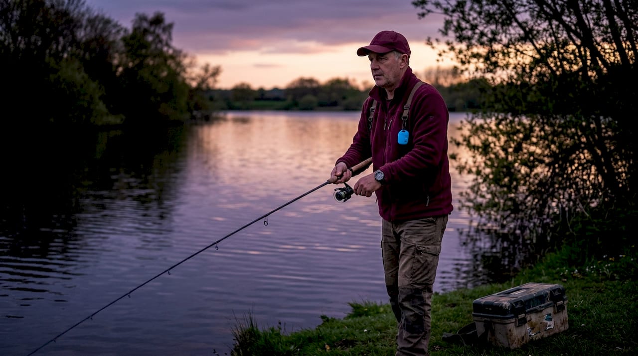 Angler casting fishing rod at misty lake dawn