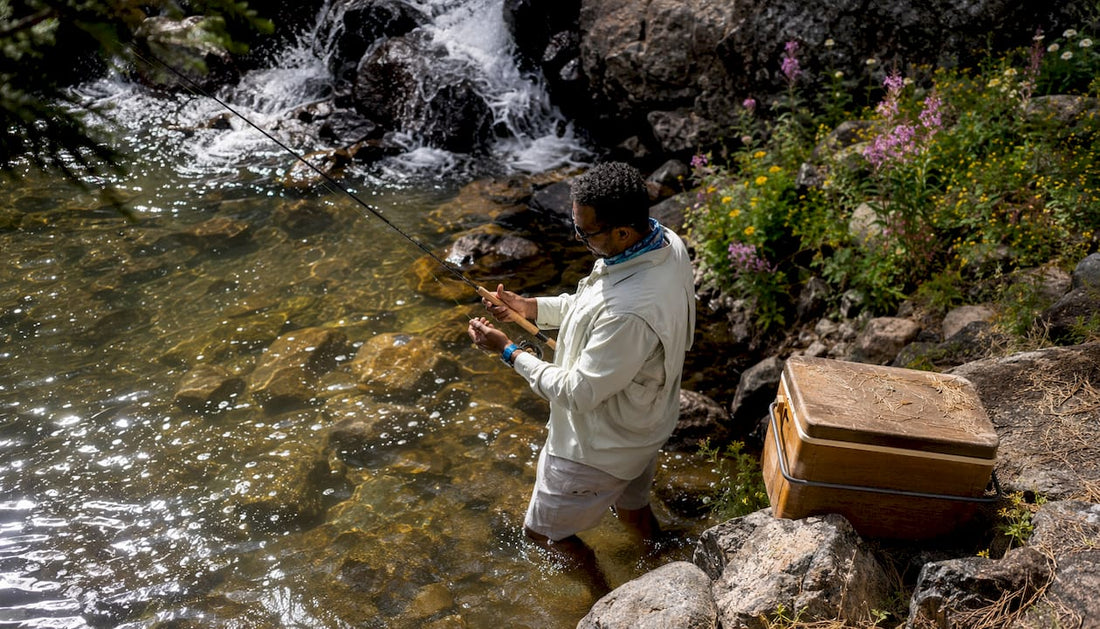 Fishing ambassador adjusting rod in stream