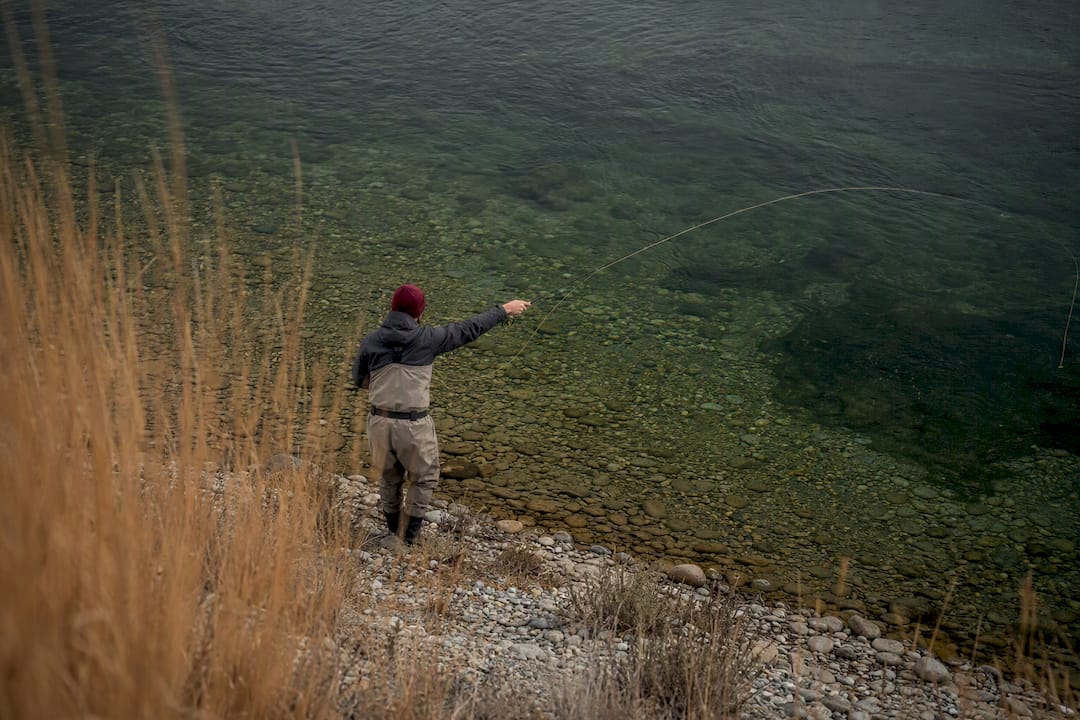Angler casting beside a clear steelhead pool